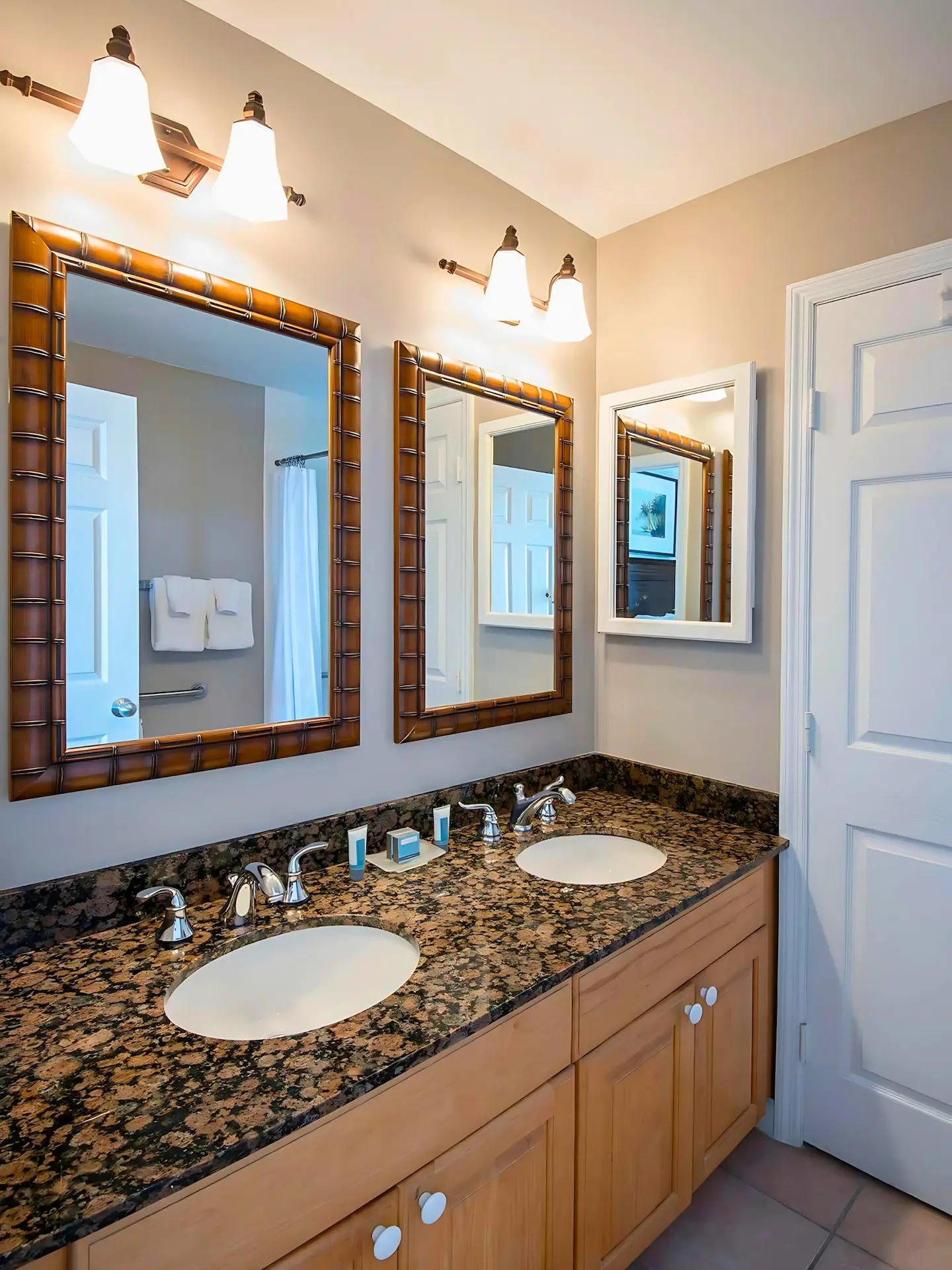 Modern bathroom with double sinks, granite countertops, and two bamboo-framed mirrors at Hawks Cay Resort.