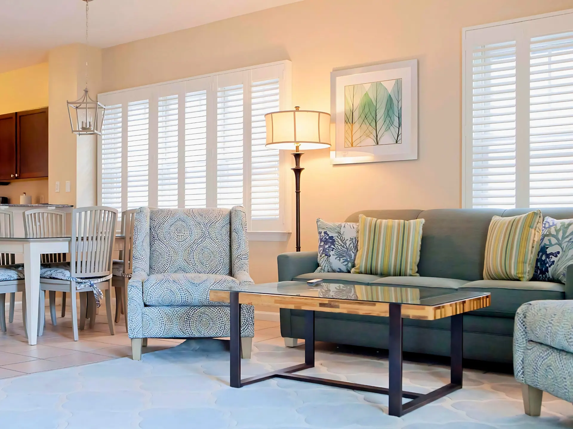 Modern 4-bedroom Hawks Cay villa living room with a green sofa, patterned armchair, and coastal decor.