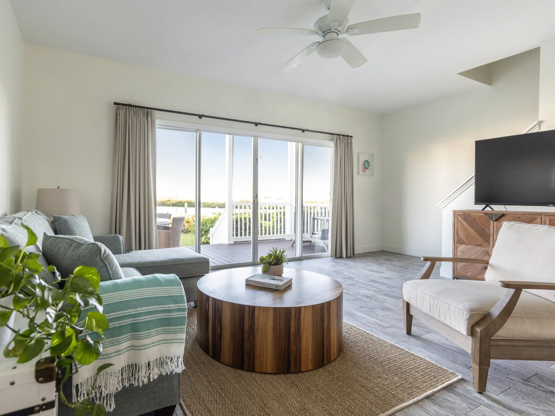 Modern 4-bedroom premium villa living room at Hawks Cay with a grey sofa and sliding doors leading to a private deck.
