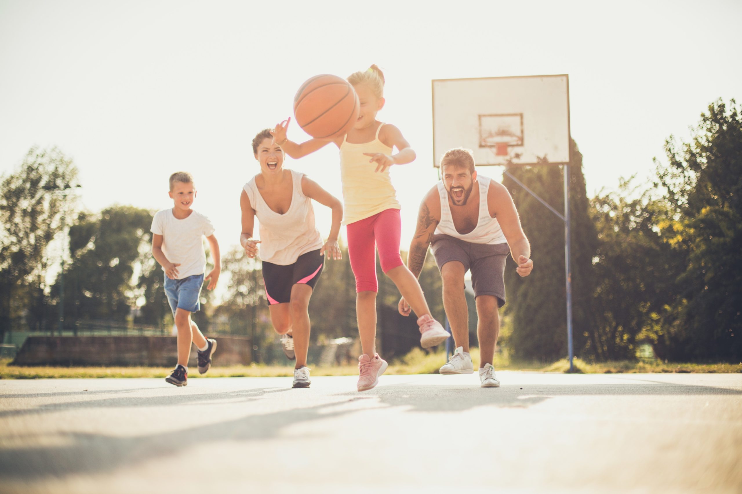 Happy family playing basketball together.